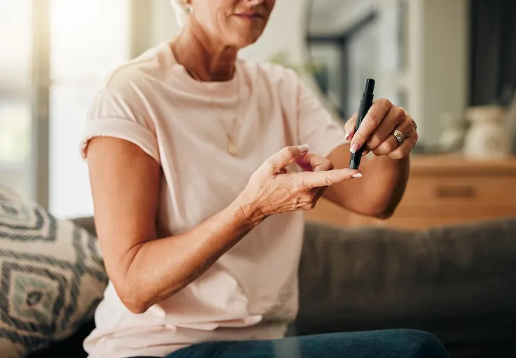 Diabetes health and elderly woman doing a blood sugar test on her finger